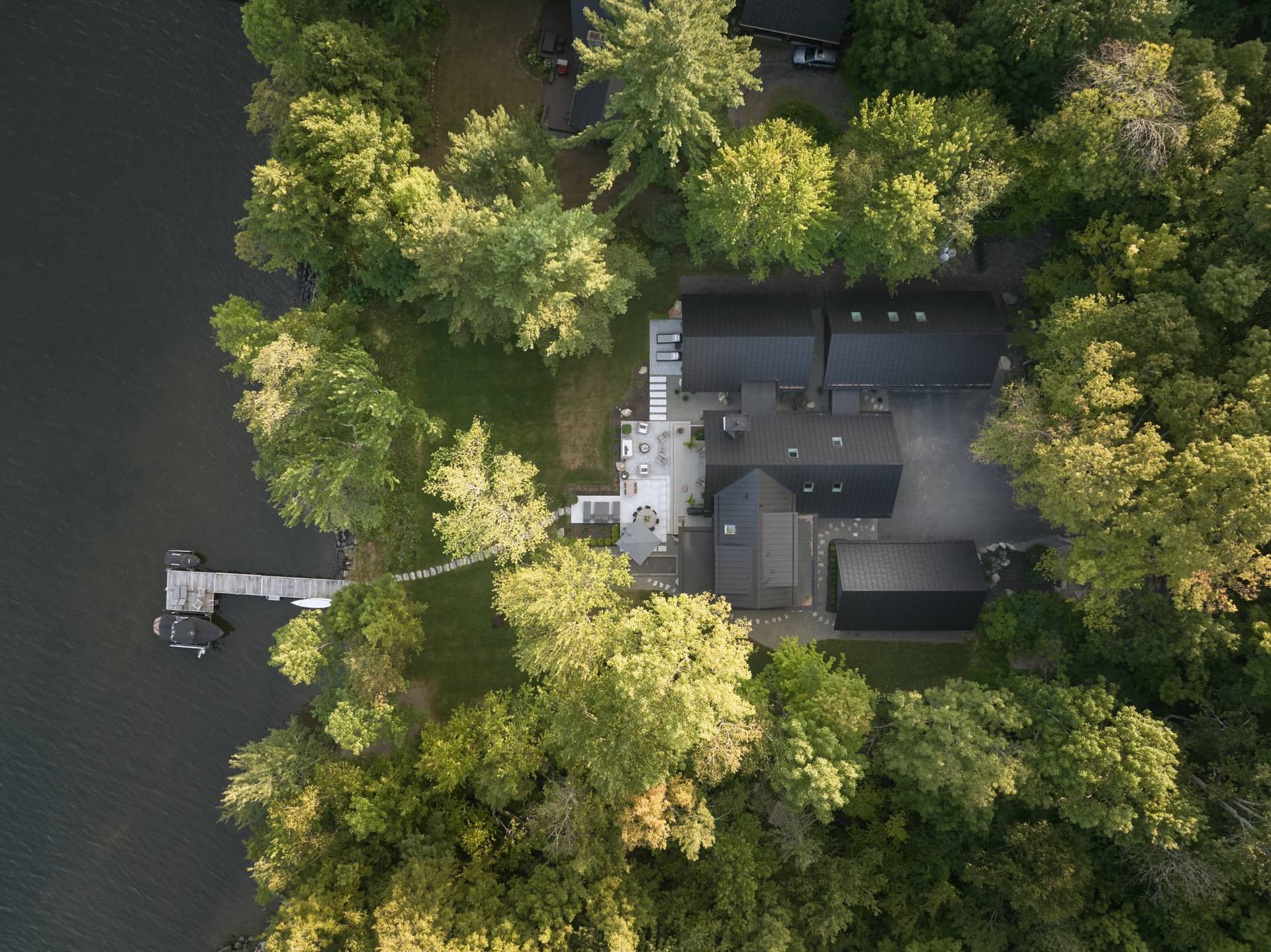 Vue aérienne de la résidence entre les arbres et le lac Brome
